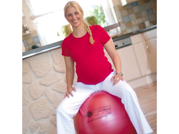 Femme enceinte assise sur le ballon de gym SISSEL® SECUREMAX® Ø55 cm rouge Femme enceinte assise sur le ballon de gym SISSEL® SECUREMAX® Ø55 cm rouge
