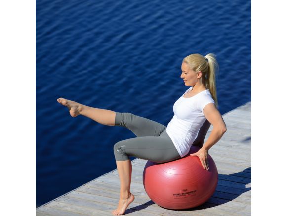 Femme en équilibre sur le ballon de gym SISSEL® SECUREMAX® Ø55 cm rouge Femme en équilibre sur le ballon de gym SISSEL® SECUREMAX® Ø55 cm rouge