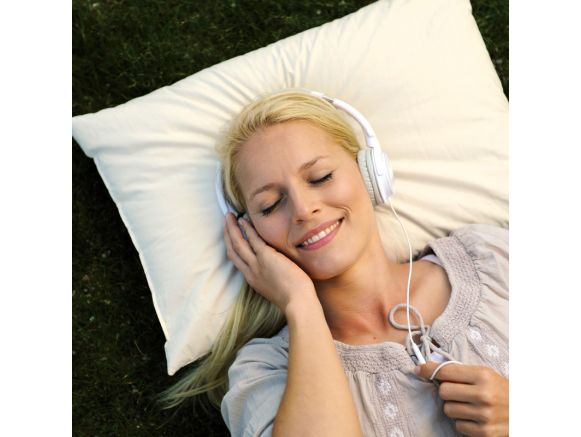 Femme écoutant de la musique avec son oreiller en balles de millet SISSEL® PANICORE Femme écoutant de la musique avec son oreiller en balles de millet SISSEL® PANICORE