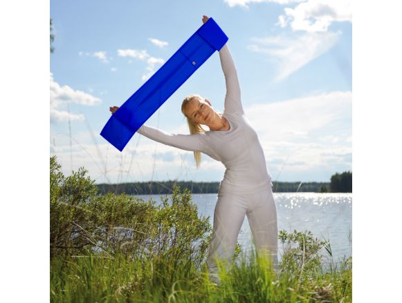 Femme pratiquant un exercice de Pilates à l'extérieur avec une bande rigide Femme pratiquant un exercice de Pilates à l'extérieur avec une bande rigide