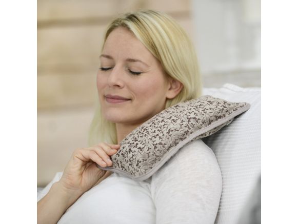 Femme utilisant la bouillotte électrique SISSEL® Heat Wave taupe sur ses épaules Femme utilisant la bouillotte électrique SISSEL® Heat Wave taupe sur ses épaules
