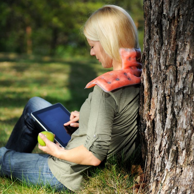 Femme appuyer contre un arbre avec la compresse auto-chauffante Therm SISSEL® dans la nuque Femme appuyer contre un arbre avec la compresse auto-chauffante Therm SISSEL® dans la nuque