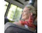 Femme assise dans le canapé avec la compresse auto-chauffante Therm nuque SISSEL®