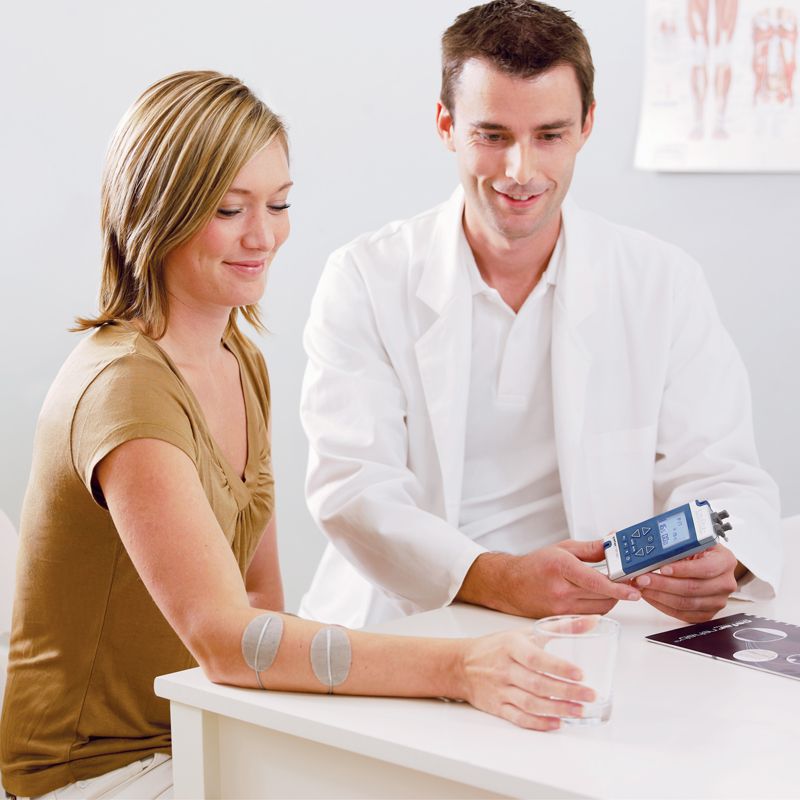 Praticien avec une patiente entrain d'utiliser le stimulateur neuromusculaire CefarCompex REHAB X2 + chargeur 4 piles