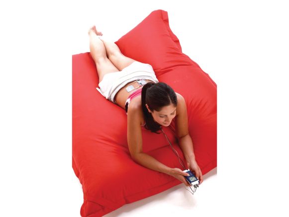 Femme allongée dans un coussin avec le stimulateur neuromusculaire CefarCompex REHAB X2 + chargeur 4 piles Femme allongée dans un coussin avec le stimulateur neuromusculaire CefarCompex REHAB X2 + chargeur 4 piles