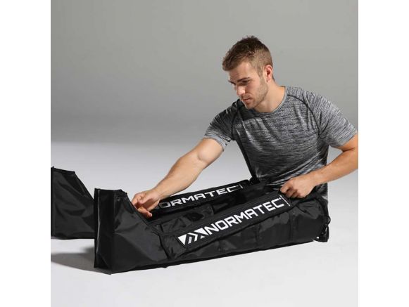 Homme utilisant les bottes de pressothérapie NORMATEC 2.0 Homme utilisant les bottes de pressothérapie NORMATEC 2.0