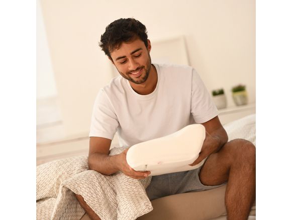 Homme assis sur son lit avec le SISSEL® PLUS Oreiller anatomique Homme assis sur son lit avec le SISSEL® PLUS Oreiller anatomique