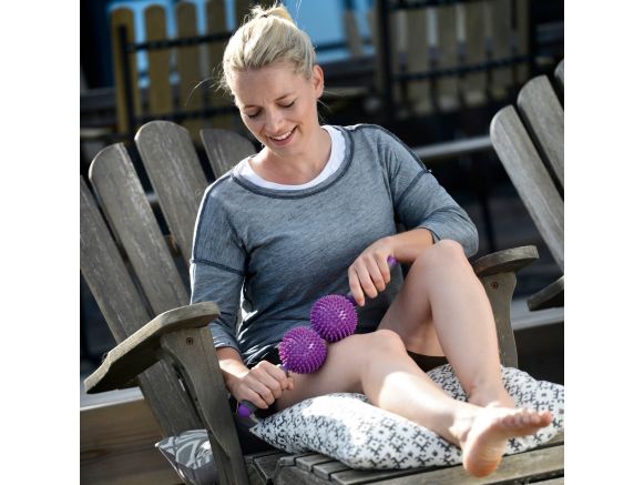 Femme avec l'appareil de Massage SISSEL® SPIKY TWIN ROLLER Violet sur le genou Femme avec l'appareil de Massage SISSEL® SPIKY TWIN ROLLER Violet sur le genou