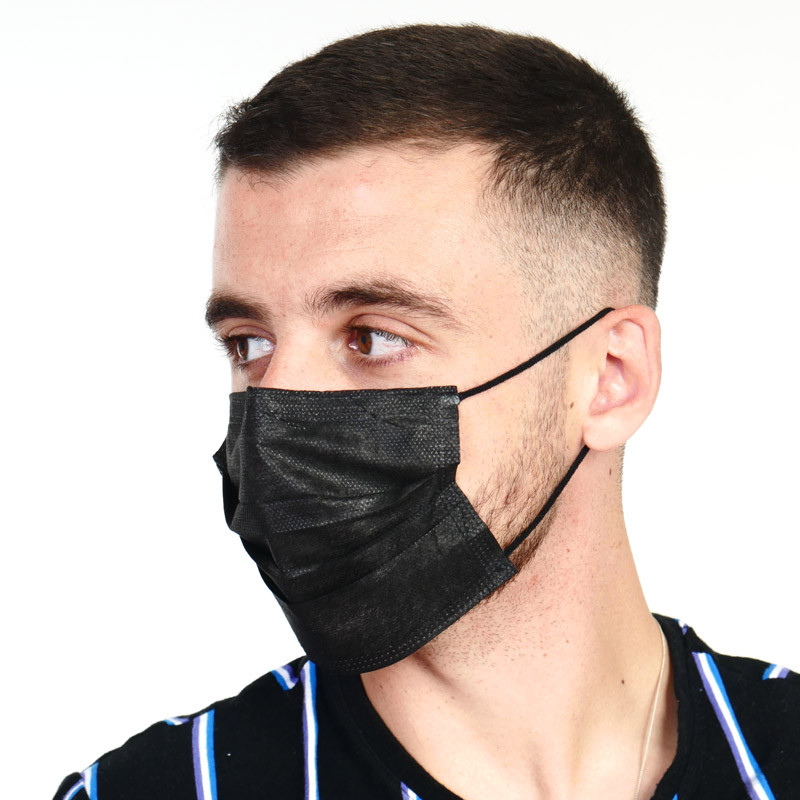 Homme de profil avec un masque noir anti-gouttelettes Homme de profil avec un masque noir anti-gouttelettes