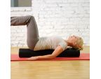 Femme avec le SISSEL® Pilates Roller Intense sur un tapis