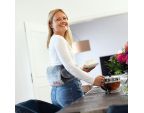 Jeune femme utilisant une COMFY BELT SISSEL® dans sa cuisine