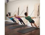 Groupe de Pilates sur les pieds avec Push through bar sur Springboard™