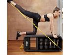 Jeune femme utilsant le banc de musculation multifonction Technogym Bench avec bande de résistance de musculation