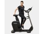 Jeune femme utilisant le vélo d'appartement compact Technogym Cycle