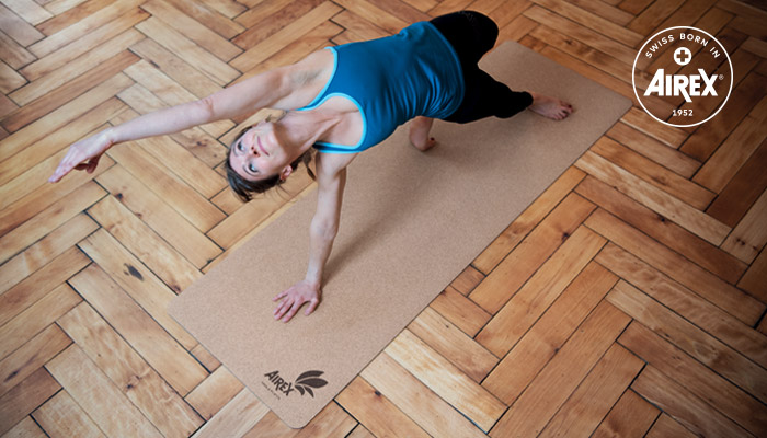 Femme réalisant un exercice sur le tapis de yoga AIREX® Eco Cork en liège